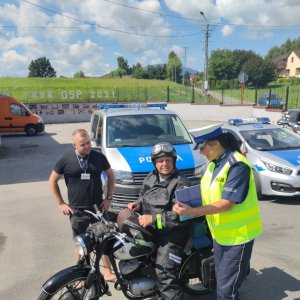 policjantka z motocyklistą w tle radiowóz i wóz radia bielsko