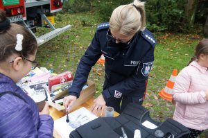 policjantka przy stoisku policyjnym w czasie pokazu pracy technika kryminalistyki