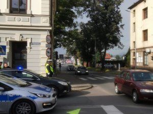 skrzyżowanie na którym stoją policjanci i przejeżdzają samochody