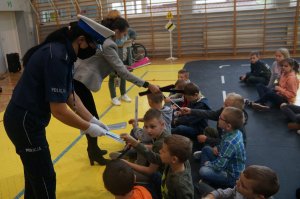 policjantka i pracownik word rozdają dziciom odblaski