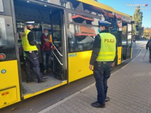 policjant stoi przed autobusem