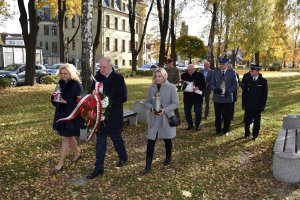 delegacja składa kwiaty i znicze na grobie