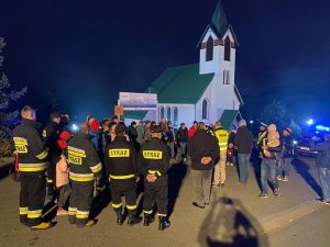 zdjęcie z akcji mieszkańcy i policjanci stoją pod kościołem