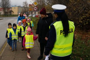 tyłem stoi policjantka przed nią parami stoją dzieci