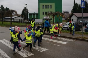 przedszkolaki przechodzą przez jezdnię pod okiem policjantki