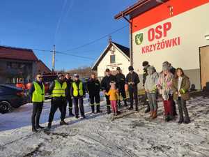 uczestnicy akcji stoją na tle budynku osp w krzyżowej