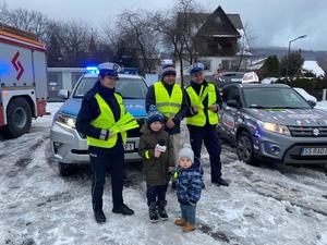 obok siebie stoją p-olicjantka, policjant i redaktor w tle samochody