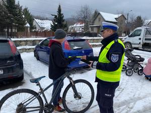 policjant wręcza odblask rowerzyście