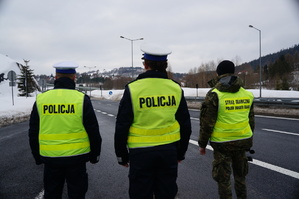 stojący tyłem dóch policjantów oraz straż graniczna w tel ulica