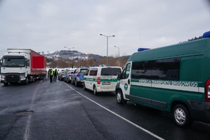 zaparkowane samochody służb po drogiej stronie zaparkowany tir funkcjonariusze obok niego kontrolują pojazd