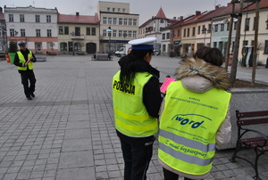 policjantka i pracownik WORD stoja obok siebie tyłem w tle zywiecki rynek