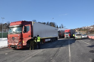 na pierwszym planie tir za nim stoją inne pojazdy obok zaparkwane samochody służb funkcjonariusze kontrolują pojazdy