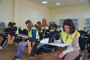 zdjęcie zrobione z przodu uczniowie piszą test na sali