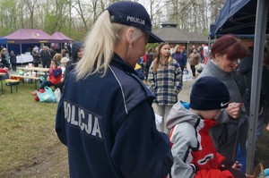 policjantka przy stoisku profilaktycznym obokstoją osobyw tle inne stoiska i ludzie