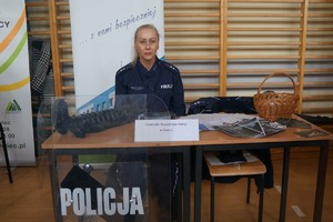 policjantka na stoisku promocyjnym siedzi za stolikiem