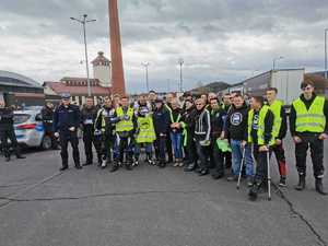 zdjęcie grupowe obok siebie stoją motocykliści i policjanci w tle pozostałe osoby, motory i radiowóz