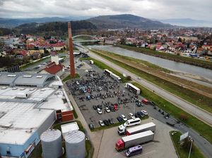 zdjęcie zrobione z góry na którym widać plac z zaparkowanymi motocyklami, samochodami, osobami i policjantami