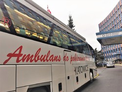 grafika poglądowaq na pierwszym planie ambulans do poboru krwi obok budynek komendy wojewódzkiej policji w katowicach