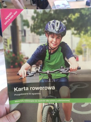 zdjęcie książeczki z przepisami ruchu drogowego na okładce chłopczyk jedzie na rowerze
