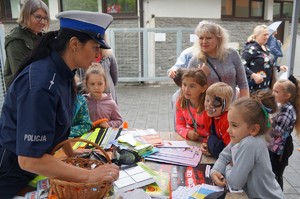 policjantka w czasie prowadzenia konkursu obok stoją dzieci