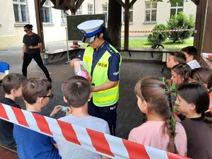 policjantka rozdaje dzieciom odblaski