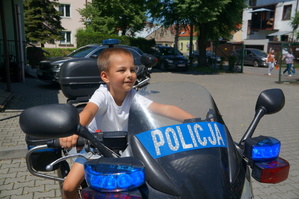 chłopczyk siedzi na motocyklu policyjnym