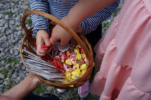 koszyk w którym są odblaski i słodycze i dziecięce dłonie trzymające odblaski i słodycze
