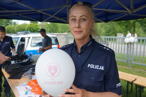 policjantka trzyma balonik z napisem stowarzyszenie przy gnieździe