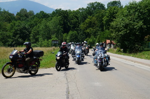 motocykliści jadący po drodze w tle góry
