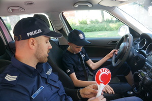 policjant i chłopak siedzą w radiowozie