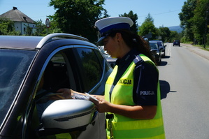 fragment policjantki wręczającej ulotki