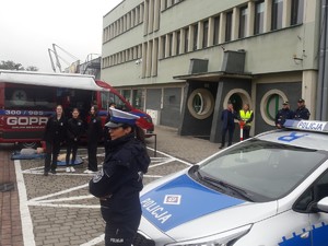 policjantka stoi obok niej radiowóz w tle partnerzy działań