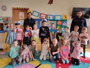 zdjęcie grupowe dzieci i policjantów dzieci trzymają odblaskowe zawieszki