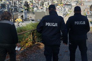 policjanci tyłem w tle cmentarz