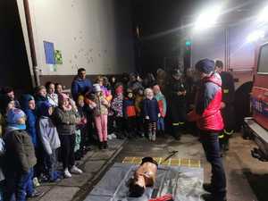 na zdjęciu widać dzieci stojące obok sienie oraz ratowników GOPR-u na ziemi leży fantom