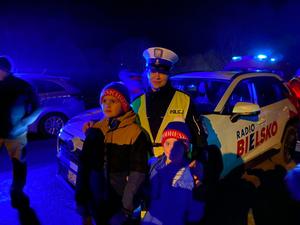 policjantka obok niej stoją dzieci w tle samochody