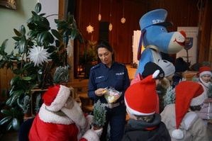 Mikołaj policjanci i sznupek rozdają prezenty dzieciom