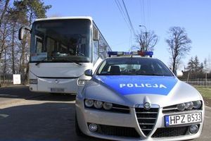 zdjęcie kolorowe na zdjęciu fragment radiowozu w tle autobus