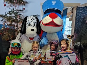 sznupek i maskotka stoku dalmatyńczyk stoją z dziećmi które wygrały nagrody