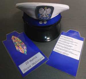 kolorowe zdjęcie policyjnej czapki oraz laurki z radami