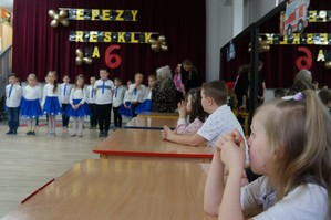 zdjęcie kolorowe zrobione w sali na środku stoją przedszkolaki które mówią wierszyki przy stolikach siedzą uczestnicy