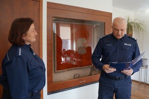 zdjęcie kolorowe zrobione w pomieszczeniu komendant powiatowy odczytuje rozkaz obok stoi policjanta