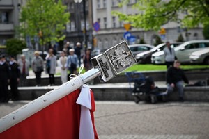 zdjęcie kolorowe z obchodów na pierwszym planie fragment flagi Polski w tle goście