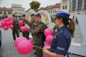 uczniowie oraz policjantka stoją z balonikami
