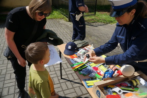 policjantka wręcza dziecku wygraną nagrodę