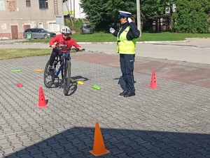 policjantka wraz ze zdającym uczniem na torze rowerowym