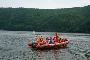łódka wopru pływająca po jeziorze z dziećmi