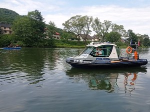 policyjna łódka w tle jezioro i brzeg jeziora