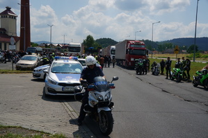 na pierwszym planie policjant na motorze za nim radiowozy i motocykliści