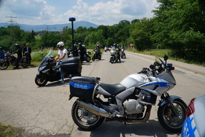 na pierwszym planie policyjny motocykl w tle  motocykliści jadący po drodze